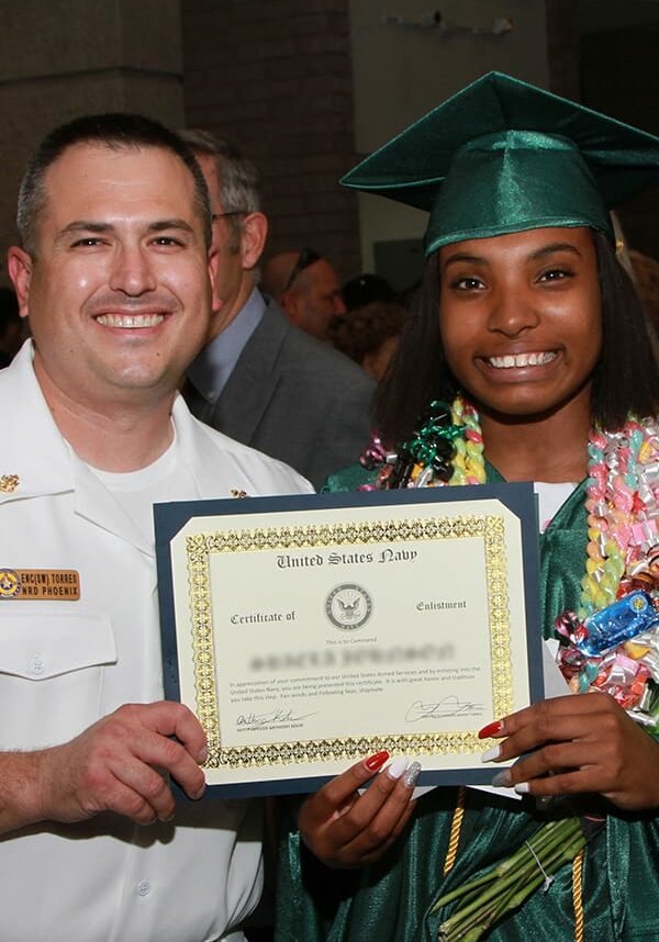 graduate accepts certificate from US Navy